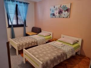 een kamer met 2 bedden en een raam bij Apartments Pero in Pula
