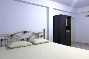 1 dormitorio con 1 cama y armario negro en OYO 92892 Aini Homestay, en Ternate