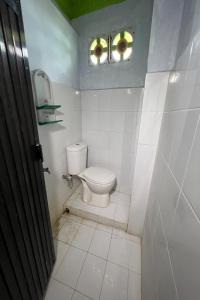 een kleine badkamer met een toilet en een raam bij OYO 92892 Aini Homestay in Ternate
