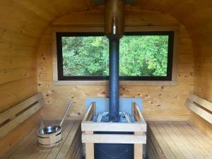 piec opalany drewnem w domku z oknem w obiekcie Szeroki Bór oaza w Puszczy z Sauną, Banią i Jacuzzi w mieście Szeroki Bór +37 zdjęć