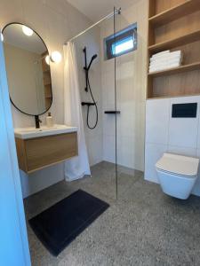 uma casa de banho com um WC, um lavatório e um espelho. em Nadmorska Otulina - Nowoczesne dwupoziomowe domki nad morzem z dużym ogrodem em Ustka