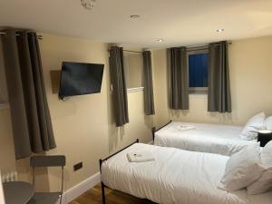 a hotel room with two beds and a flat screen tv at Twin Room With En-Suite in Edinburgh