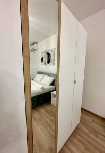 einen Spiegel vor einem Schlafzimmer mit einem Bett in der Unterkunft Apartman Maja in Srbobran