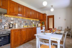 a kitchen with wooden cabinets and a white table at Mansion House in Neápolis