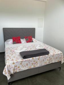 een bed met een deken en rode kussens erop bij Villa 4 Princesses in Vela Luka