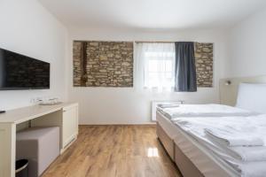 - une chambre avec 2 lits, un bureau et une fenêtre dans l'établissement Hotel Barborský dvůr, à Kutná Hora