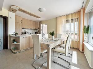 a kitchen and dining room with a table and chairs at Golf Villa Ariel in Kavarna