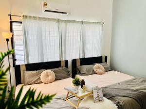 1 dormitorio con 2 camas con almohadas y mesa en Laksamana Gathering Homestay BP en Batu Pahat