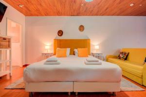 a bedroom with a large bed and a couch at Herdade da Granja Nova in Montargil