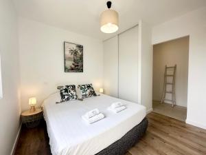 1 dormitorio con 1 cama blanca grande y 2 almohadas en LES ARÈNES - Lumineux - Centre-Ville en Mont-de-Marsan