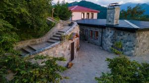 a stone building with stairs next to a house at GAFULLUK BUNGALOV in Araklı