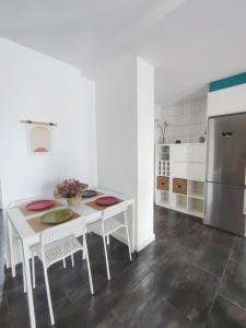 een witte keuken met een tafel en een koelkast bij Agarimo Home in Virxe das Mareas