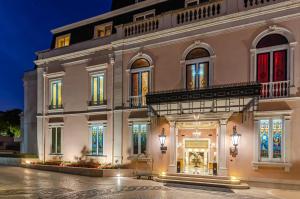 een groot wit gebouw met verlichting bij Olissippo Lapa Palace – The Leading Hotels of the World in Lissabon