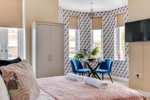 1 dormitorio con 1 cama, mesa y sillas en Bright studio with turret and parking by Eagle Owl Property en Worthing