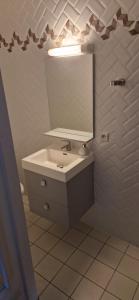 y baño con lavabo y espejo. en Chambres d'Hôtes d'Aliénor, en Soulac-sur-Mer
