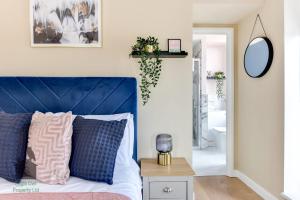 a bedroom with a blue bed with a blue headboard at Bright studio with turret and parking by Eagle Owl Property in Worthing