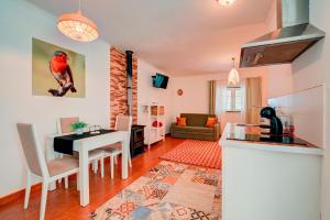 - une cuisine et un salon avec une table et un oiseau sur le mur dans l'établissement Herdade da Granja Nova, à Montargil