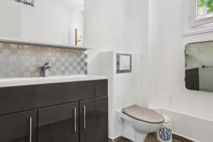 a bathroom with a toilet and a sink at Maison charmante avec jardin et parking offert Paris St Cloud in Saint-Cloud
