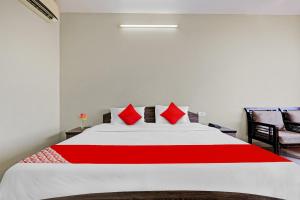 sypialnia z dużym białym łóżkiem z czerwonymi poduszkami w obiekcie SPOT ON 81091 Gmall w mieście Haldwani