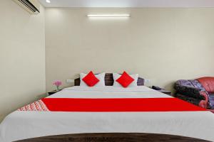 a bedroom with a large bed with red pillows at SPOT ON 81091 Gmall in Haldwāni