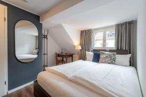 sypialnia z dużym łóżkiem i lustrem w obiekcie Hotel am Fischmarkt w Konstancji