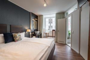 Hotel am Fischmarkt في كونستانز: غرفة نوم مع سرير أبيض كبير في غرفة