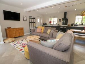 uma sala de estar com dois sofás e uma cozinha em Bodlywydd Fawr - Annexe em Ruthin