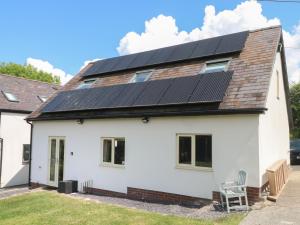 uma casa com painéis solares no telhado em Bodlywydd Fawr - Annexe em Ruthin