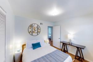 Habitación blanca con cama y escritorio en Manchester Escape en Santa Bárbara
