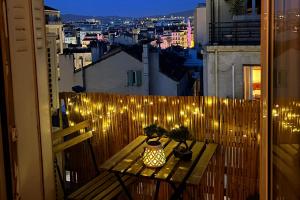 Un balcón con una mesa con luces. en Central and blight flat with balconies, en Marsella
