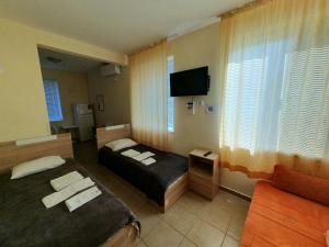 a hotel room with two beds and a television at Viriks in Atanasovo