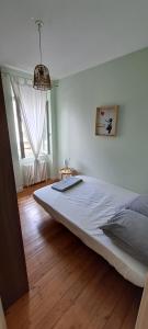 1 dormitorio con 1 cama blanca grande en una habitación en Jolie maison de ville avec un extérieur au calme - Les Dragons de la Chamoiserie NIORT, en Niort