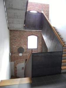 - un escalier dans un bâtiment en briques avec une fenêtre dans l'établissement Hotel Alter Hafenspeicher, à Stralsund