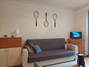 a living room with a couch and tennis rackets on the wall at Casa Nevosa by Holiday World in Prato Nevoso