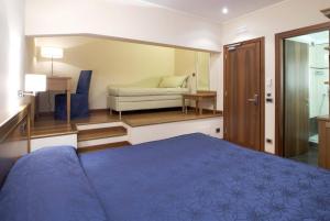 a bedroom with a bed and a couch in a room at Hotel Iris in Genoa