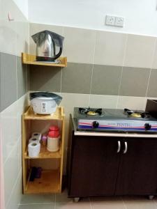 a kitchen with a stove and a counter top at Homestay Camelia Kuala Terengganu Houses 3 Room 2 Bathroom - Near Batu Buruk Beach , Drawbridge, Pasar Payang, KTCC Mall & Hospital HSNZ in Kuala Terengganu
