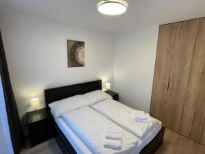 een slaapkamer met een bed met twee handdoeken erop bij Apartmán Gréner in Svit