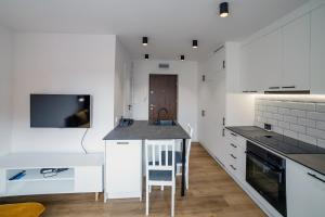 a kitchen with white cabinets and a kitchen island at Apartament Alpaka 2 in Lidzbark Warmiński