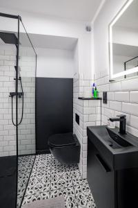 a bathroom with a black toilet and a sink at Apartament Alpaka 2 in Lidzbark Warmiński