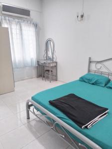 een ziekenhuisbed in een kamer met een tafel bij Welcome to Gemas Homestay ALI 