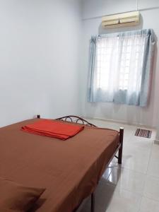 een slaapkamer met een bed met een rode deken erop bij Welcome to Gemas Homestay ALI 