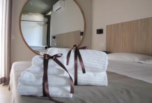 una pila de toallas en una cama con espejo en SOHO B&B, en Fisciano
