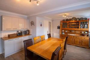 a kitchen and dining room with a wooden table at Sandy Bottom - 4B op. dunes, Pool Table & Juke Box in Camber