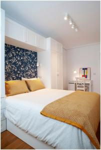 um quarto com uma grande cama branca com almofadas amarelas em Luminoso y Azul em Avilés