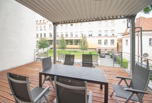 una terraza de madera con mesa y sillas en Room&Go: Zentral - Terrasse - Weber Grill, en Halle an der Saale