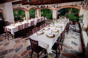 a long dining room with white tables and chairs at Modrzewiowy Zdrój 