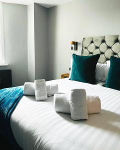 a bedroom with a large white bed with towels on it at 1 West End Boutique Apartment in Bowness-on-Windermere