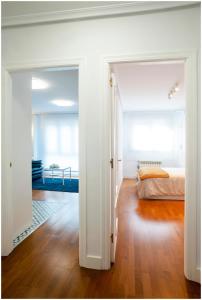 uma porta aberta para um quarto com uma cama em Luminoso y Azul em Avilés
