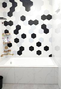 baño con pared hexagonal en blanco y negro en Homestay KS Kota Bharu, en Kota Bharu