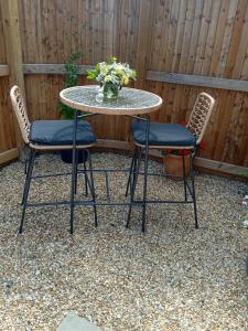 a table with two chairs and a vase of flowers at The Old Garage in West Itchenor